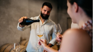 A person pours wine into a glass