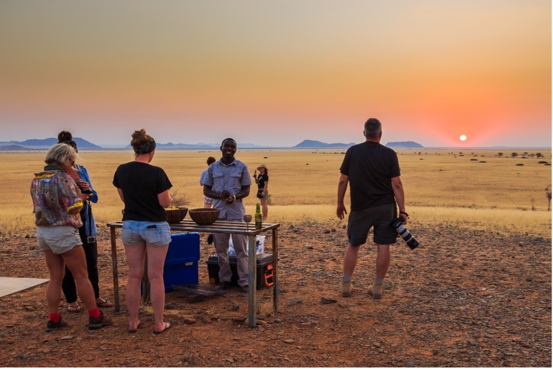 People in a dessert at sunset